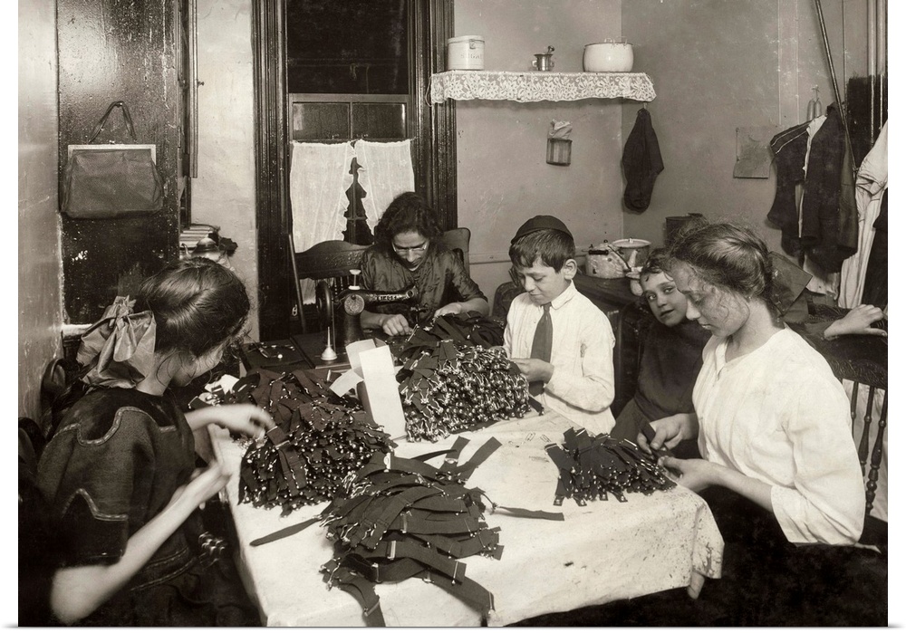 A Jewish family making garters in the kitchen of their tenement home in New York City, New York. Photograph by Lewis Wicke...