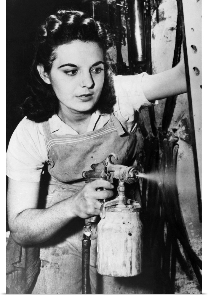 A woman spraying paint on electrical control equipment in a factory in Pittsburgh, Pennsylvania. Photograph, 1942.