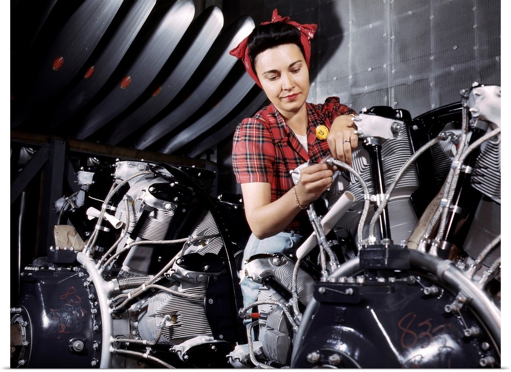 A woman working on an airplane motor at the North American Aviation plant in California. Photograph by Alfred T. Palmer, J...