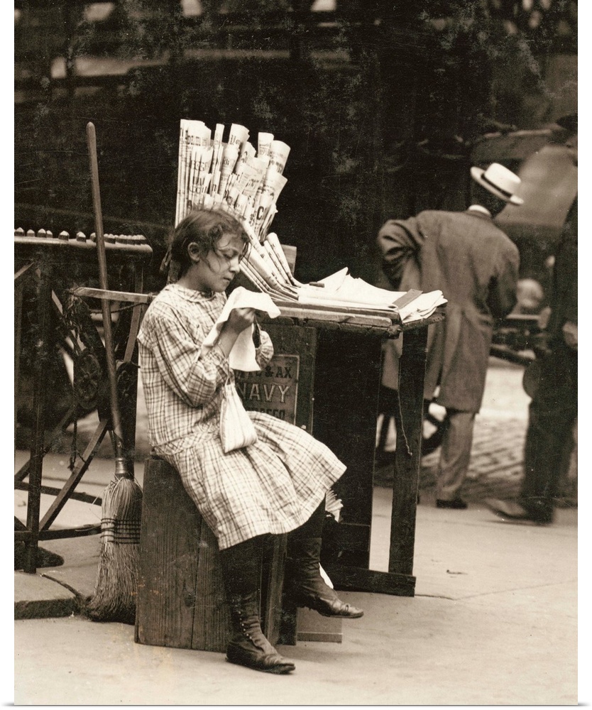 A young newsgirl seated on a crate while tending to the newspaper stand on the Lower East Side of Manhattan, New York. Pho...