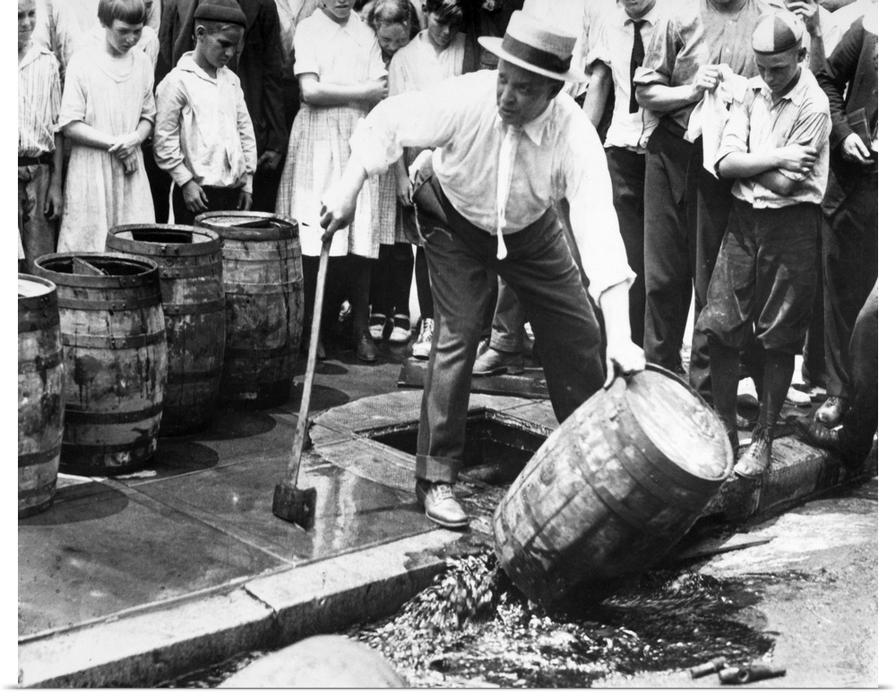 An American official dumping kegs of bootleg liquor into the sewer during Prohibition. Photograph, c1925.