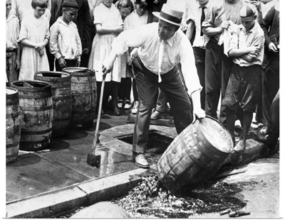 An American official dumping kegs of bootleg liquor into the sewer during Prohibition