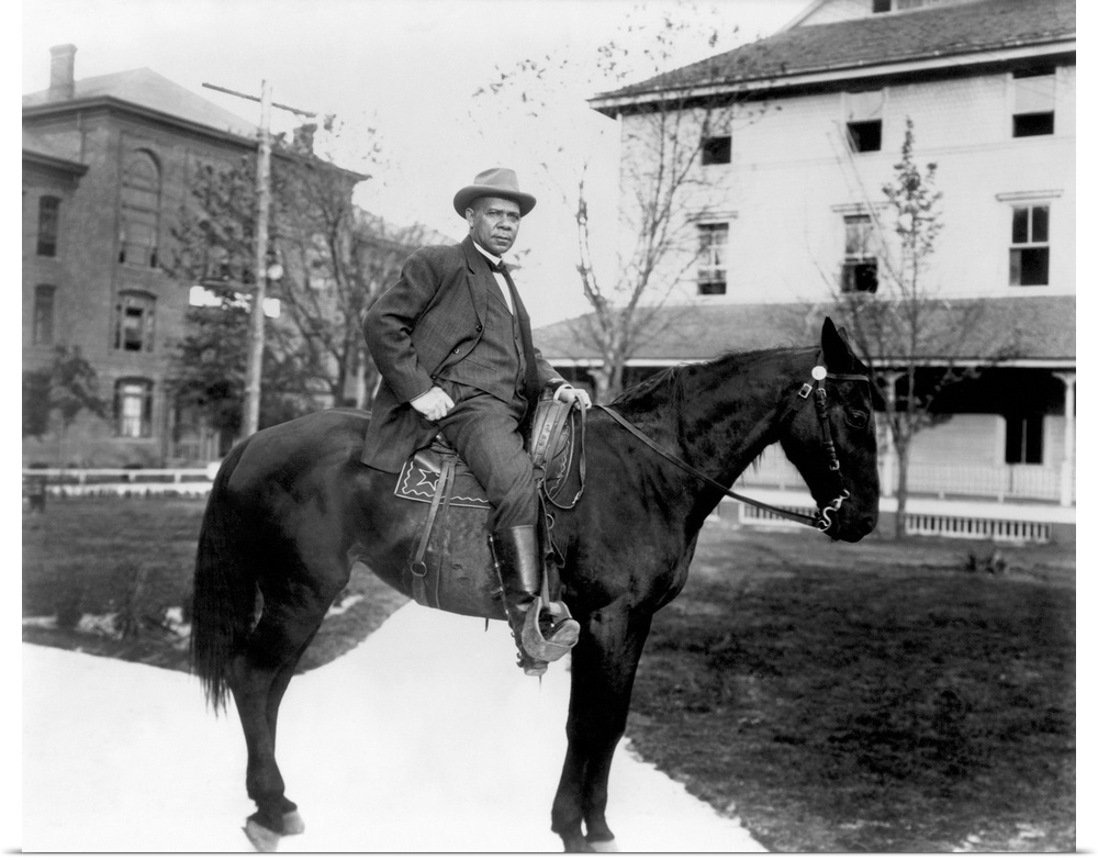BOOKER T. WASHINGTON (1856-1915). American educator. On horseback at the Tuskegee Institute in 1906.
