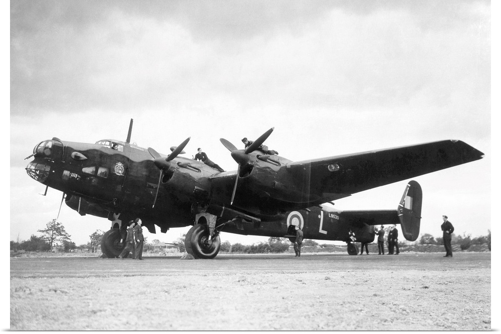 Crew members service a Handley Page Halifax bomber plane of the British Royal Air Force.