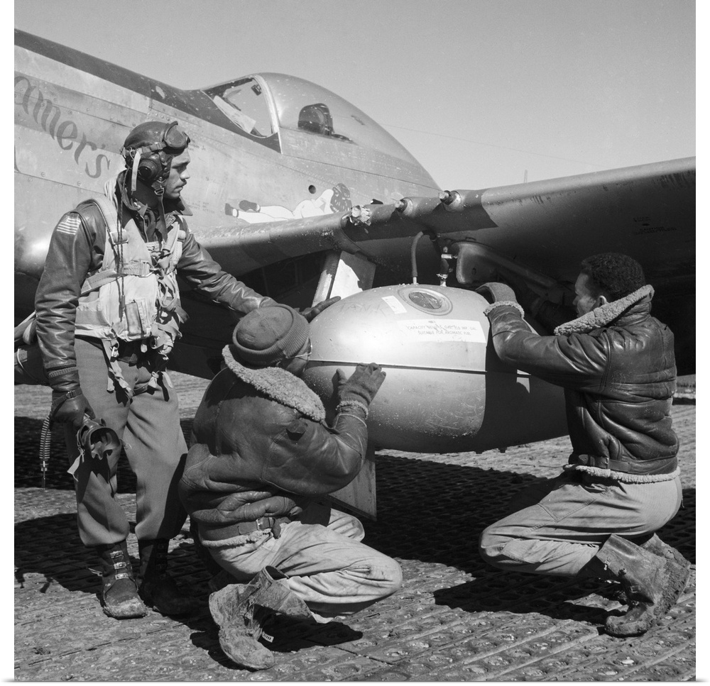 Edward Gleed and two other Tuskegee Airmen adjust an external 75 gallon drop tank on the wing of a P-5
