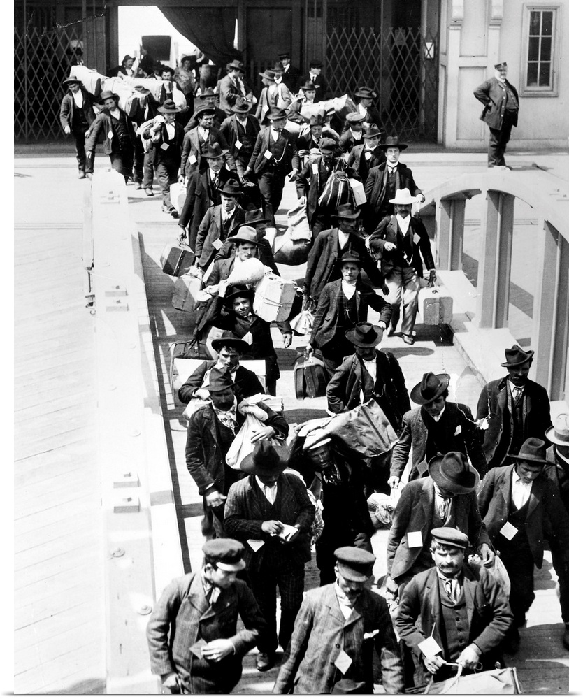 Immigrants arriving at Ellis Island with their belongings. Photograph, c1910.