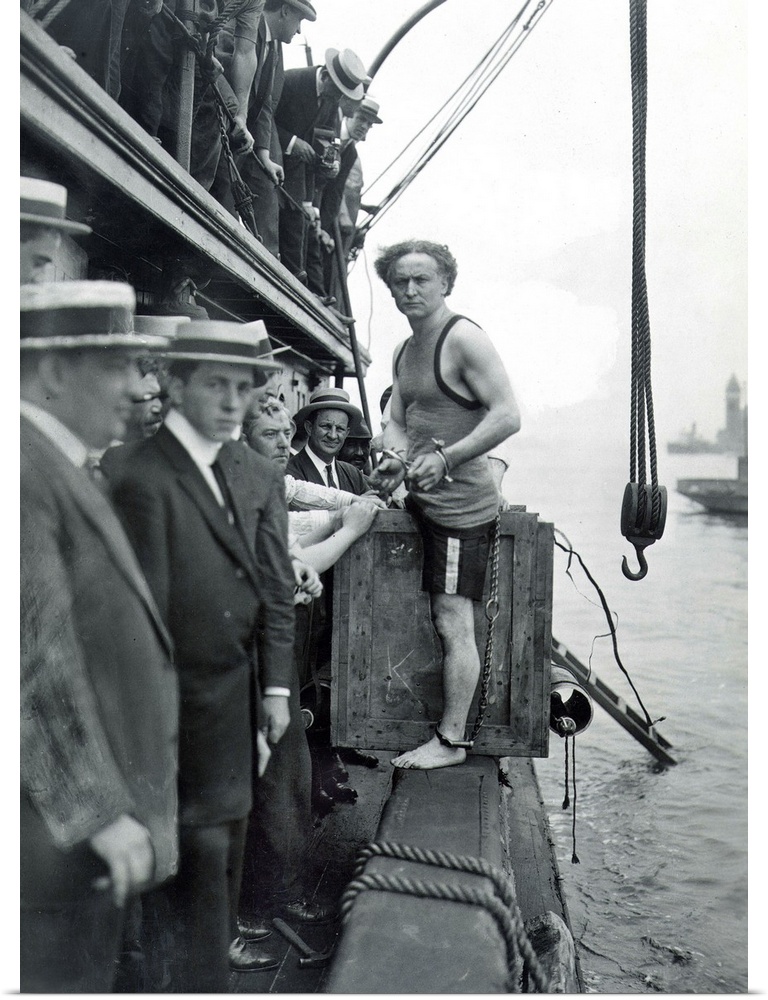 American magician. A shackled Houdini about to be padlocked into a packing case and lowered into New York harbor, 1914.