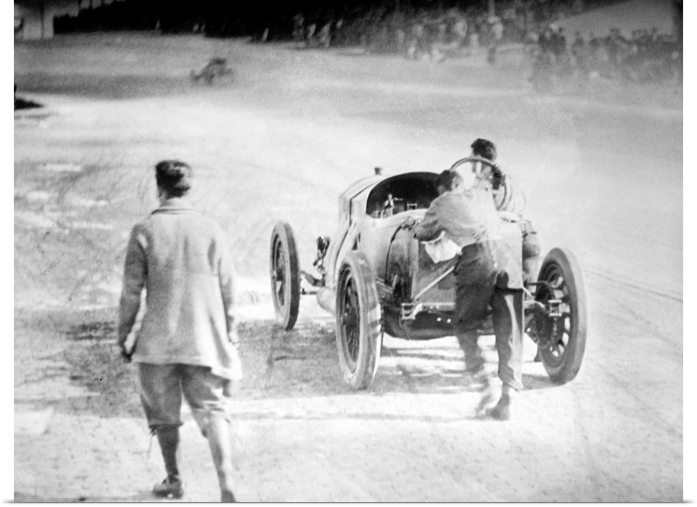 Driver Ralph DePalma, right, and his riding mechanic Rupert Jeffkins push their broken down car towards the finish line at...