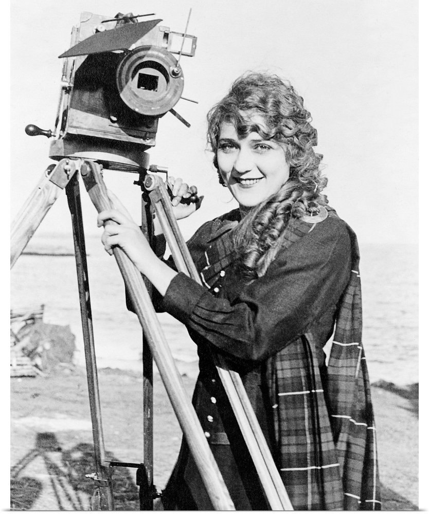 Born Gladys Mary Smith. American actress, with a movie camera on a beach, c1916.