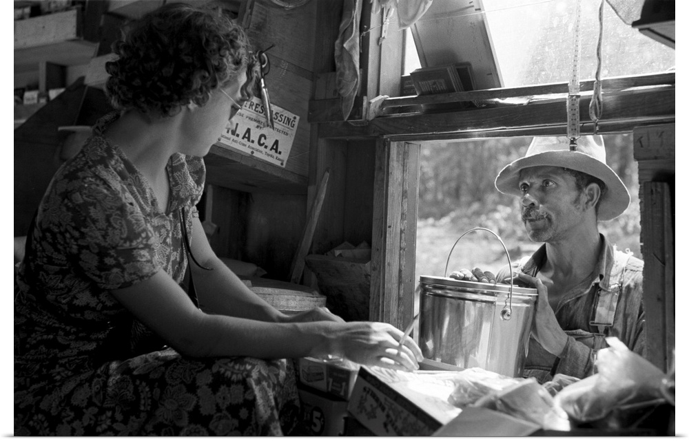 An African American sharecropper making a purchase from the traveling grocery store truck, Forrest City, Arkansas. Photogr...