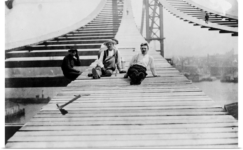 Workers resting on footpaths on the Manhattan Bridge during its construction, c1909.