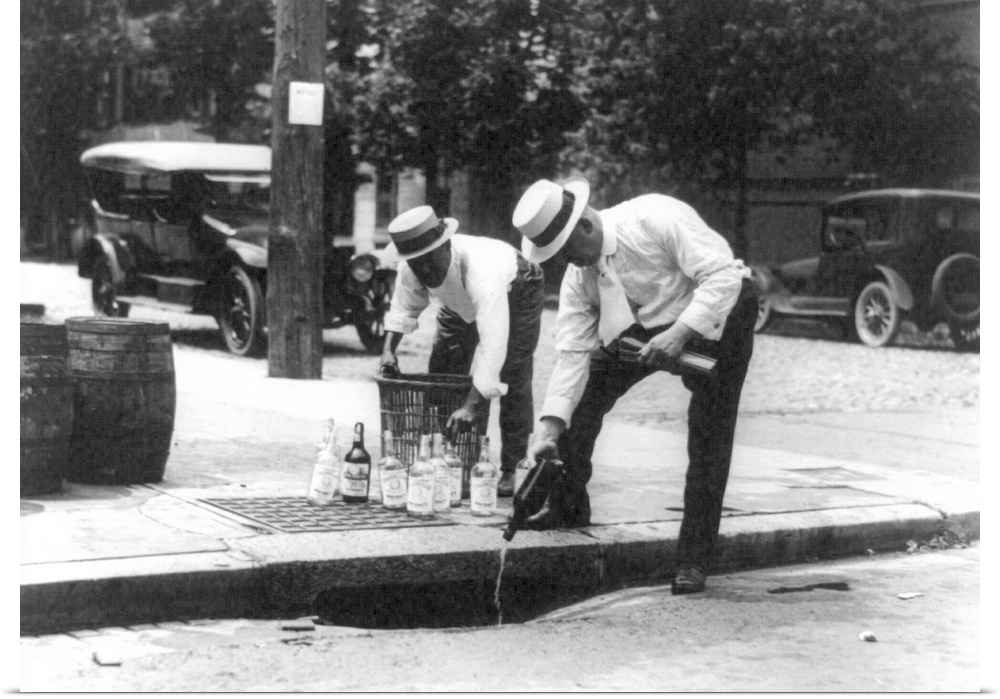 Men pouring bootleg whiskey into a sewer during Prohibition in America, 1920s.