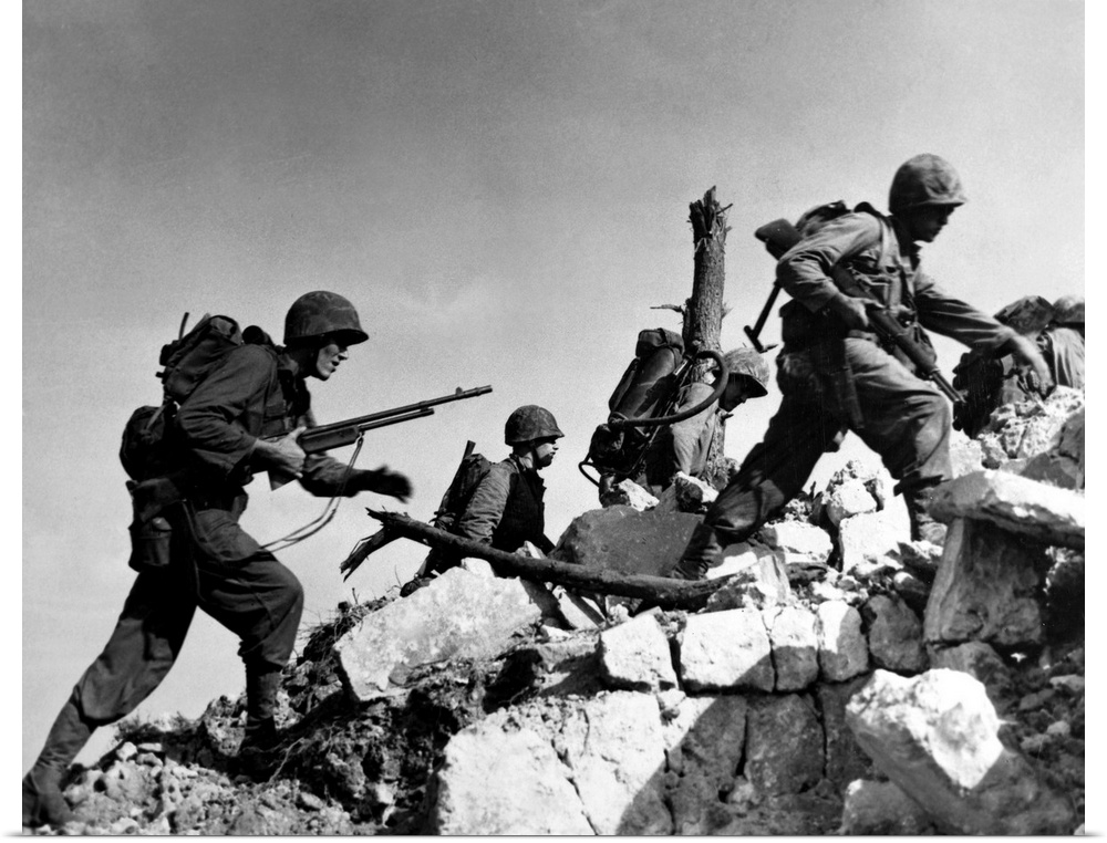 U.S. Marines hurdle a stone wall during the Battle of Okinawa, 1 April 1945.