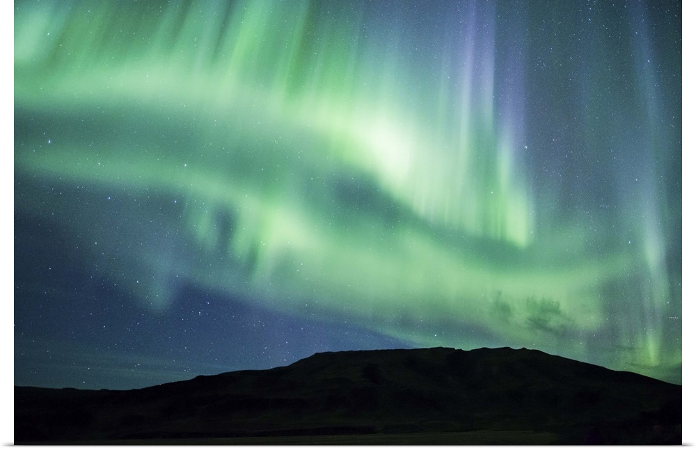 Vivid green and blue Northern Lights in the sky above the South Coast of Iceland.