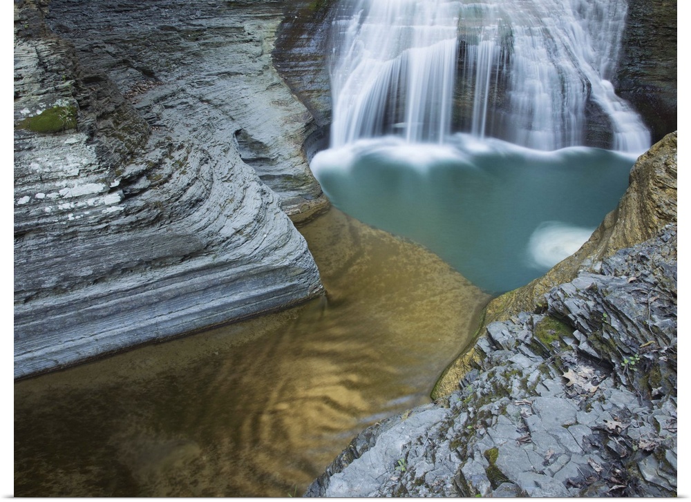 Waterfall and a turquoise pool among striated rock formations in Ithaca, New York.