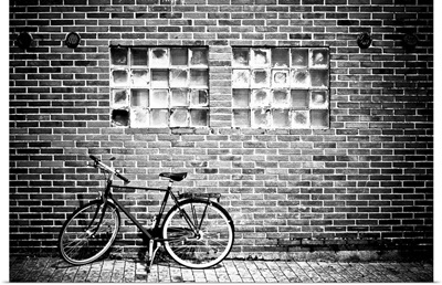 A bicycle beside a brick wall