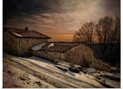 A winter scene with snow of an old house at dusk
