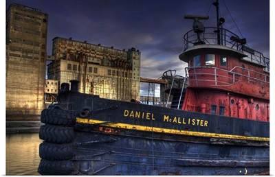 An old tug boat near to industrial buildings