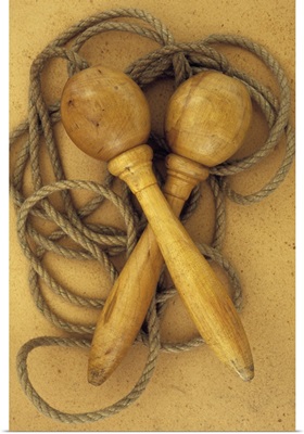 Close up of traditional skipping rope with wooden handles lying on antique paper