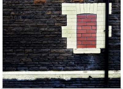 Derelict bricked in window with drainpipe