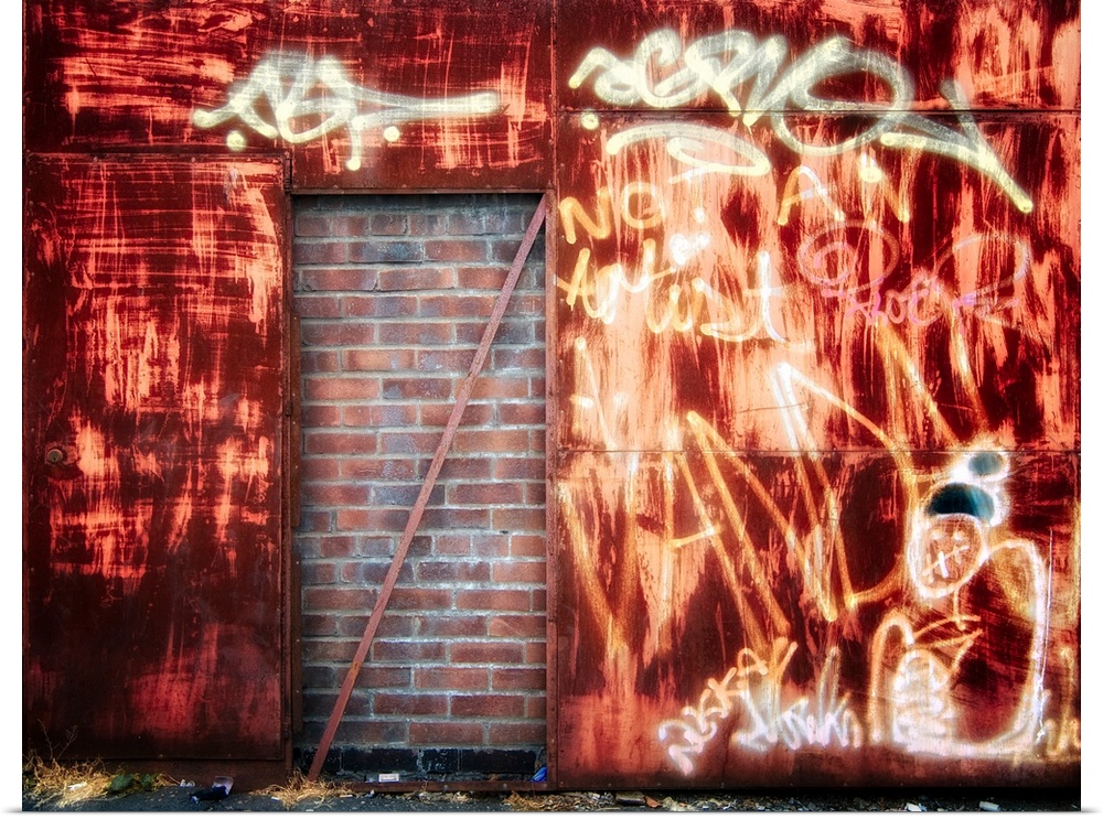 Filled in derelict door with red brickwork and graffiti