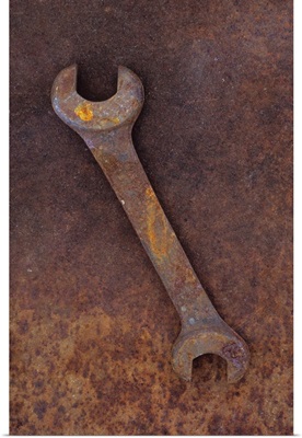 Heavy double-headed spanner lying on rusty metal sheet