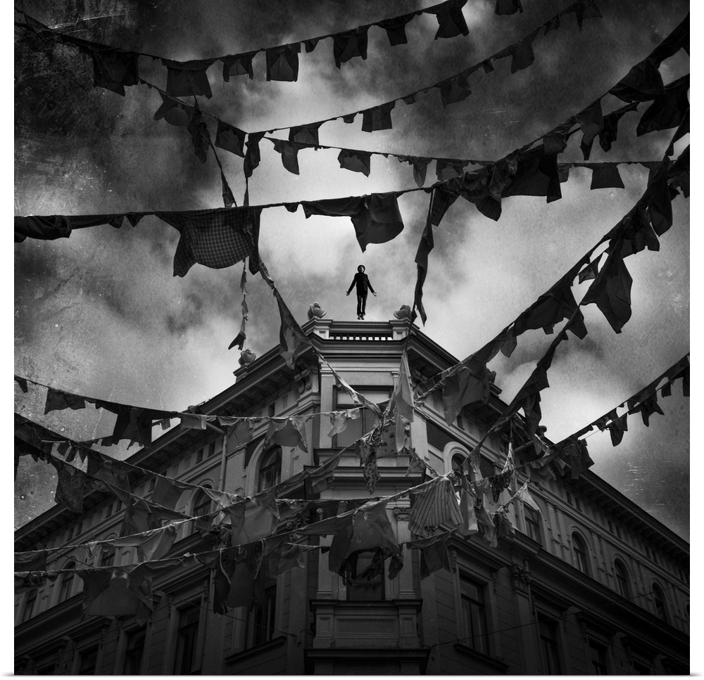 Conceptual image of young adult male falling from tall building with clothes hung from bunting across street