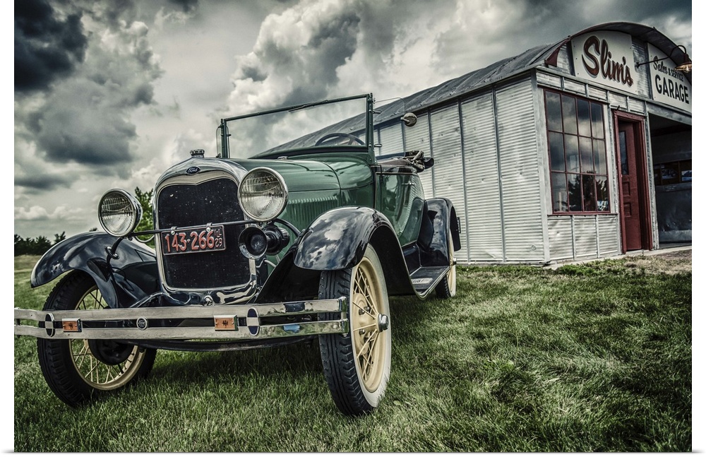 Vintage Model T Ford parked outside tin garage called Slim's on grass under cloudy sky