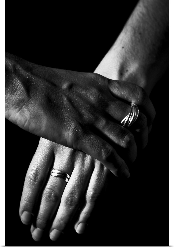 Two women's hands, over a black background