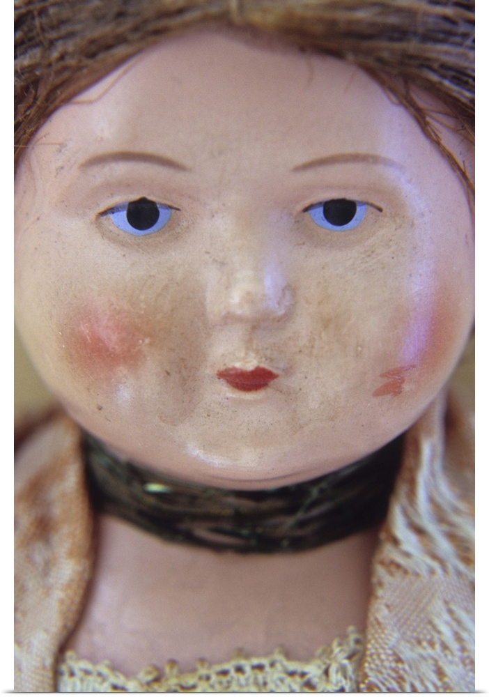 Face of vintage woman doll with tight bun and glum face and wearing lacy clothes and neckband