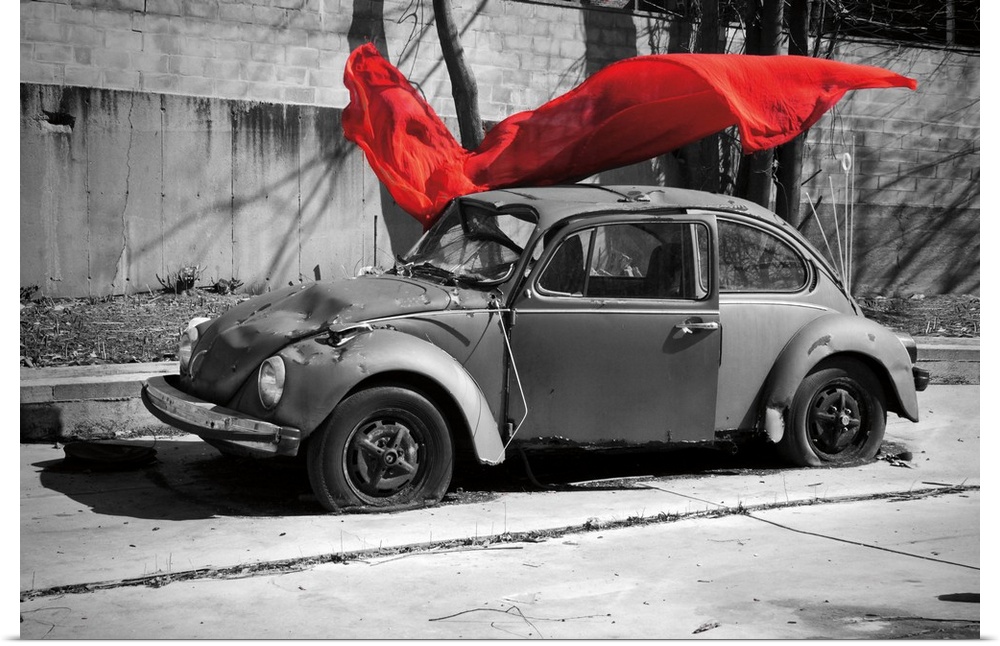 A black and white photograph of a car with a colorized red cloth hanging in the air.