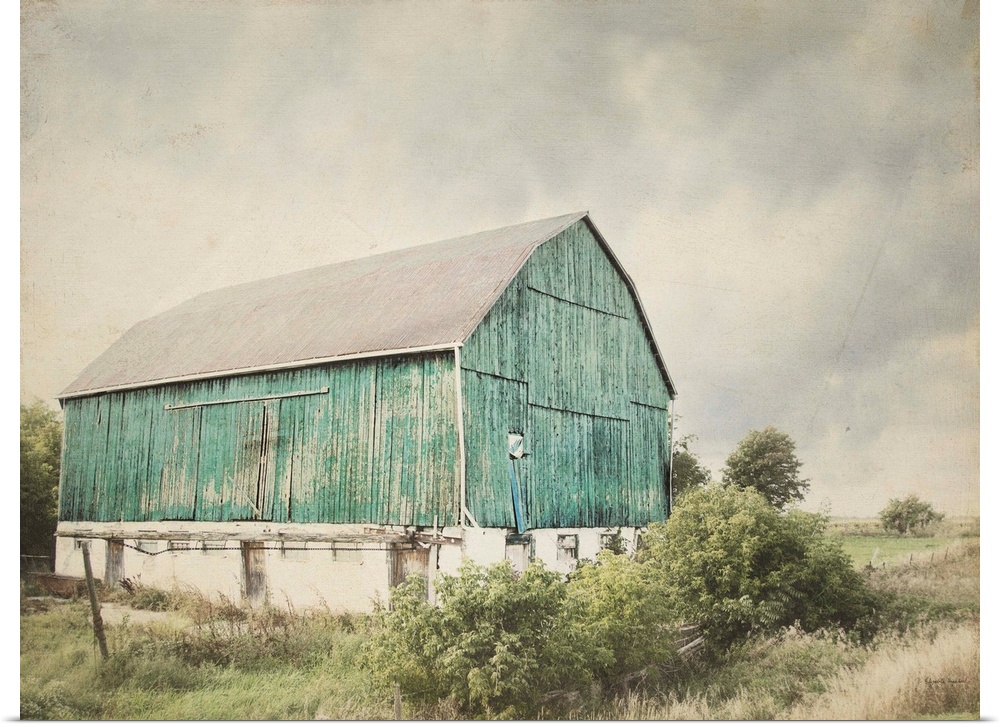 Rustic photograph with distressed edges of an aged barn in a countryside landscape.