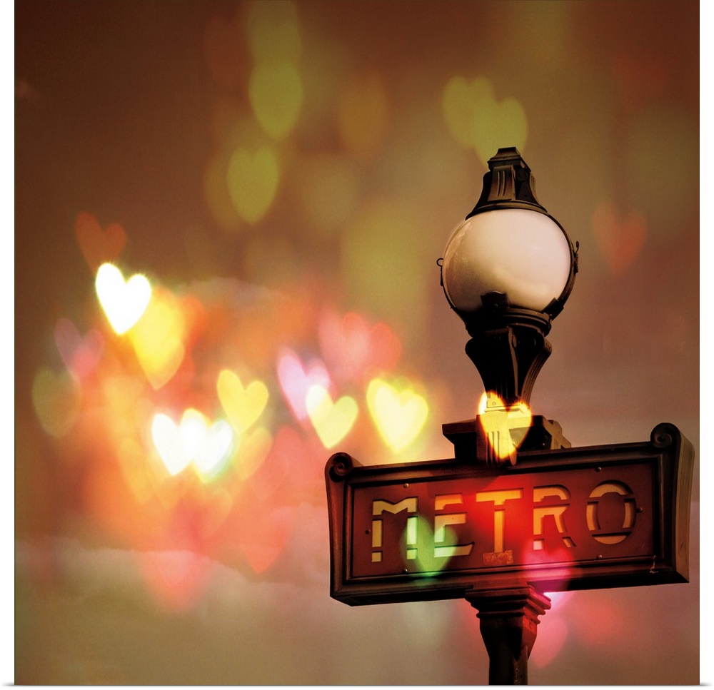 Square photograph of a metro street post in Paris with heart shaped bokeh in the background.