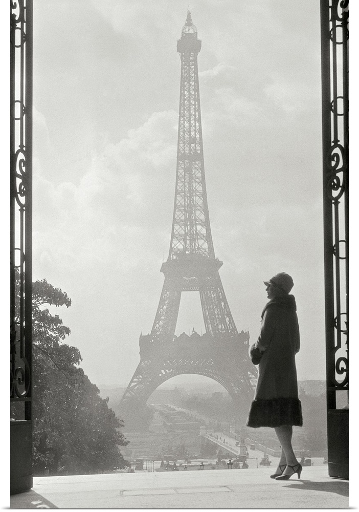 Vintage photograph of a stylish woman standing in an art deco gateway with the Eiffel Tower in the background.