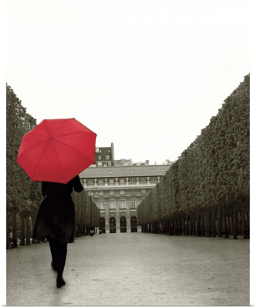 A photograph of a person walking down an empty road with a red umbrella overhead.