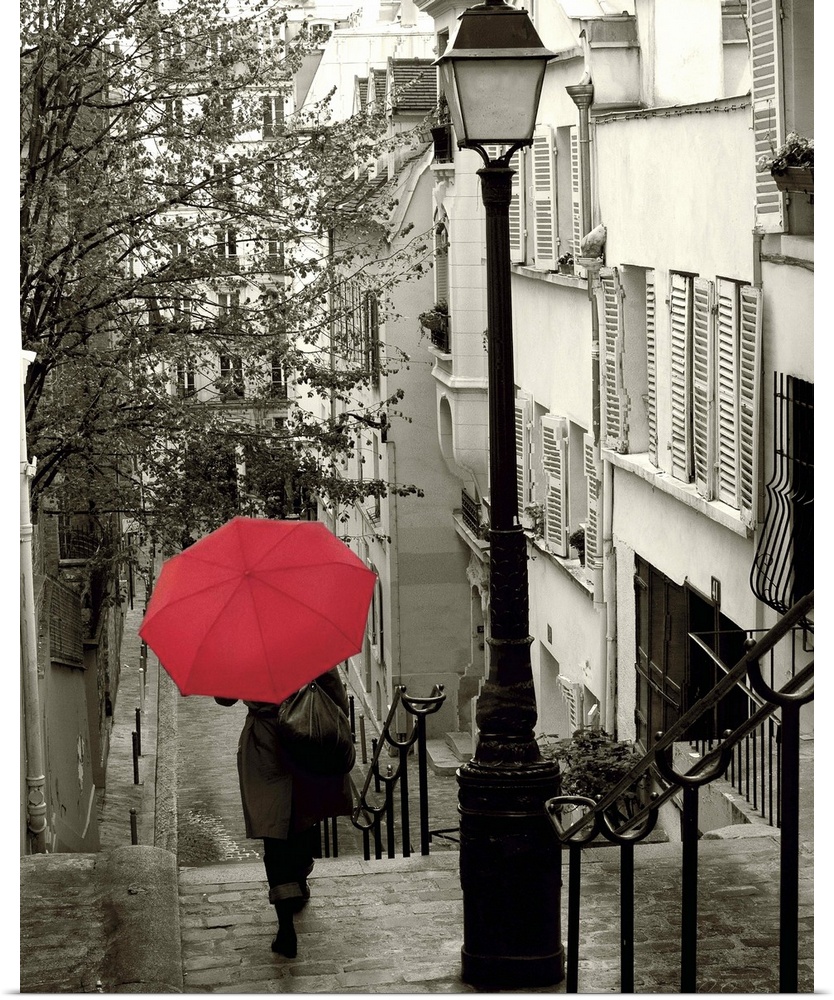 A photograph of a person walking down an empty neighborhood corridor with a red umbrella overhead.