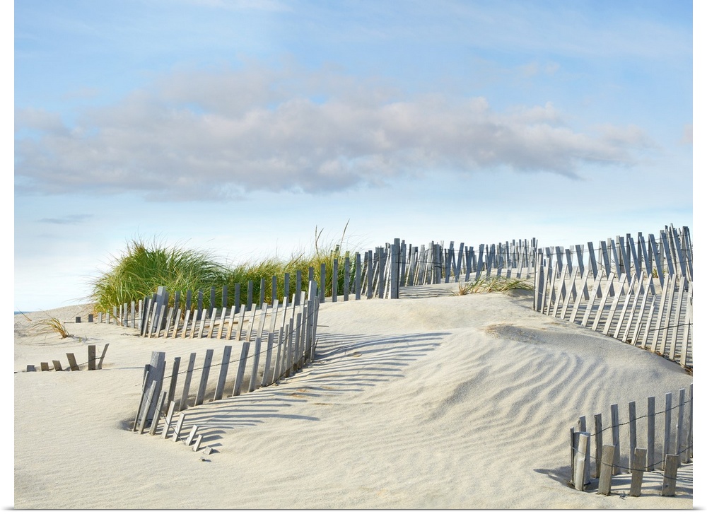 Photograph with leading lines following the wooden fence on the sand dunes at the beach.