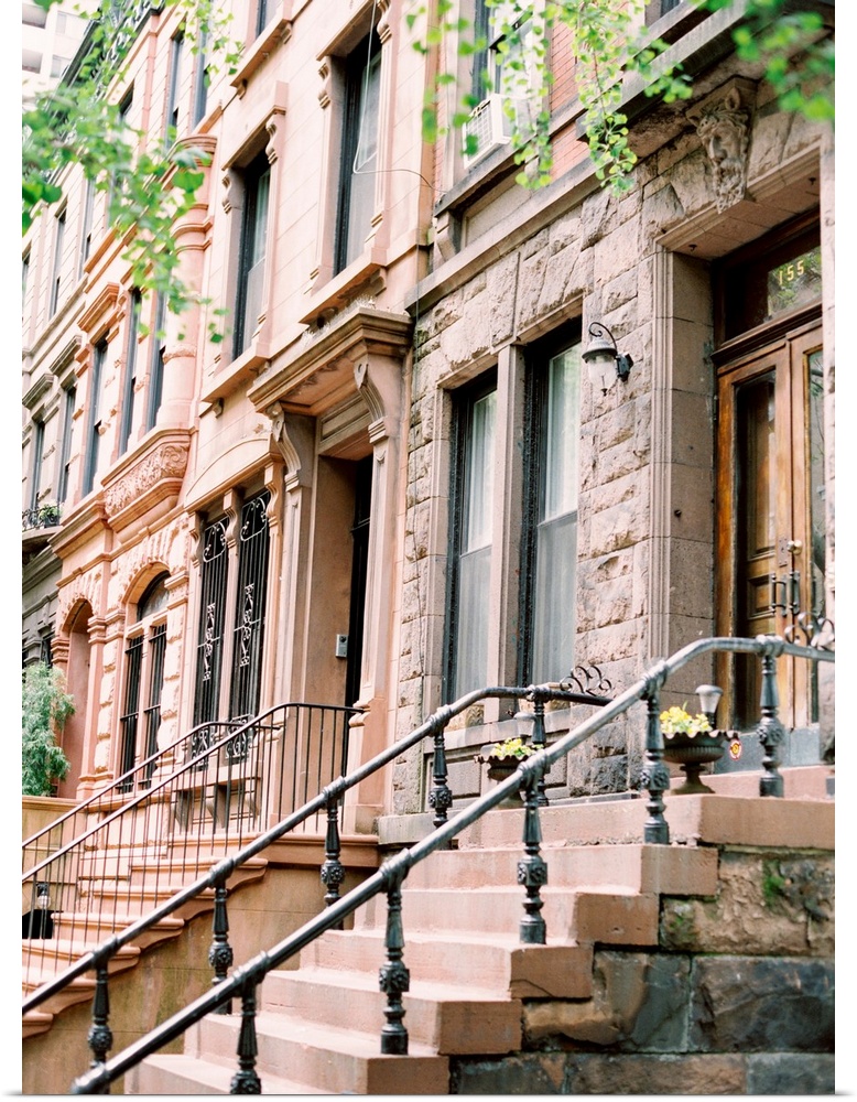 Photograph of brick and cement steps leading up to an iconic Brownstone house in New York.