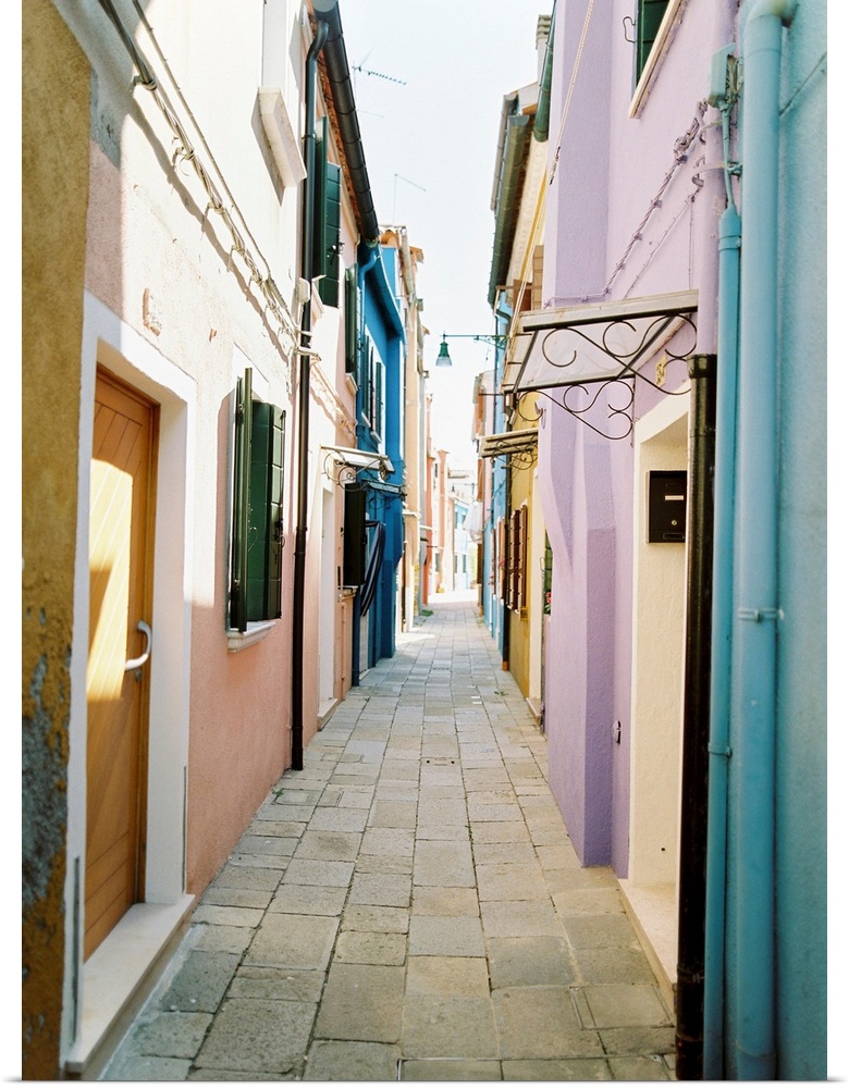 Photograph of brightly painted houses in a narrow alleyway, Burano, Italy.