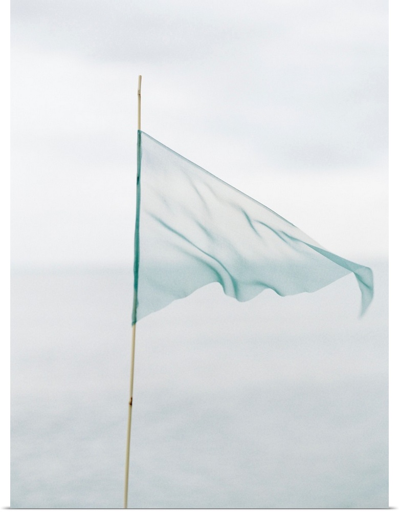 Photograph of a delicate blue flag made from thin fabric on a bamboo pole.