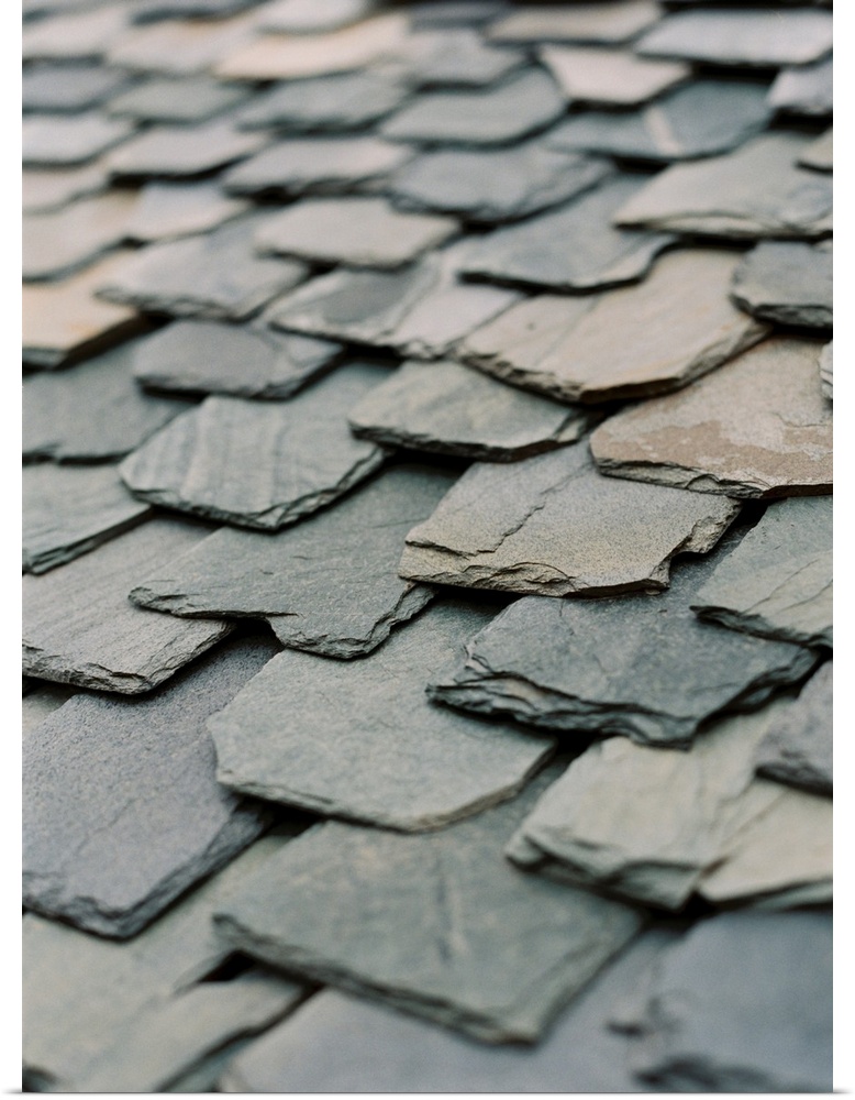 A close up photograph of hand-hewn stone slates on a rustic roof.