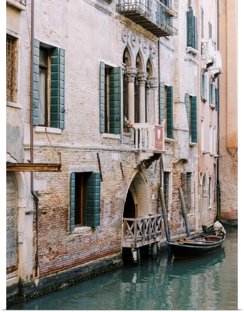 A photograph of the facade of a house on a canal, Venice, Italy.
