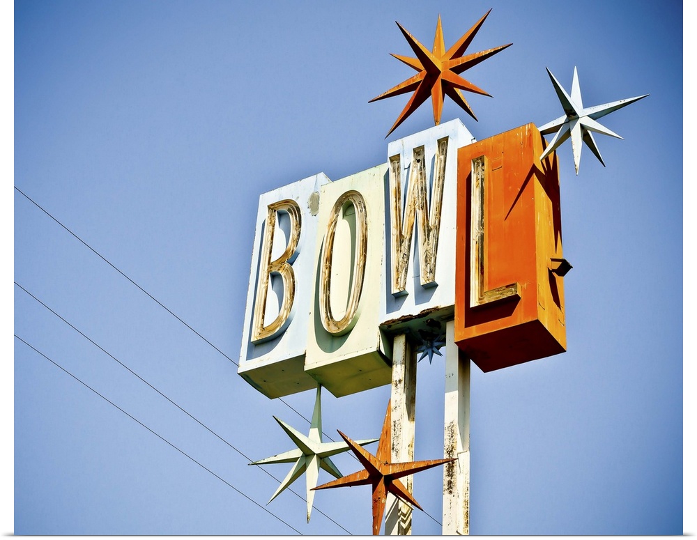 Photograph of a retro bowling sign against a clear blue sky.