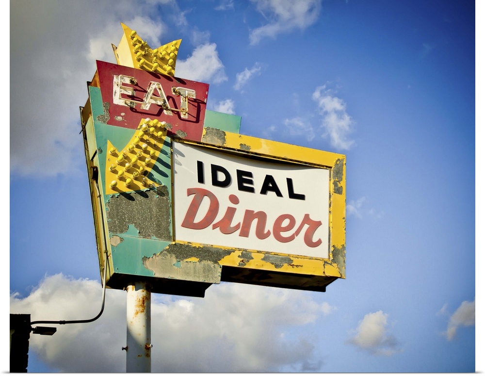 Photograph of a retro restaurant sign against a cloudy blue sky.