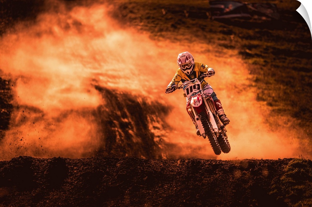 A photograph of a motocross rider caught in the air while riding a dirt track.