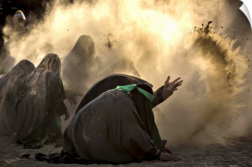 A group of people bending down and tossing dust into the air, iran.