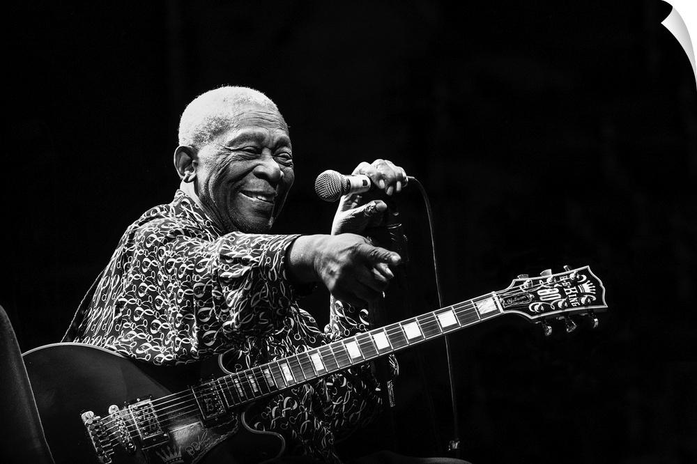 Portrait of a blues musician on stage pointing to a fan in the crowd.