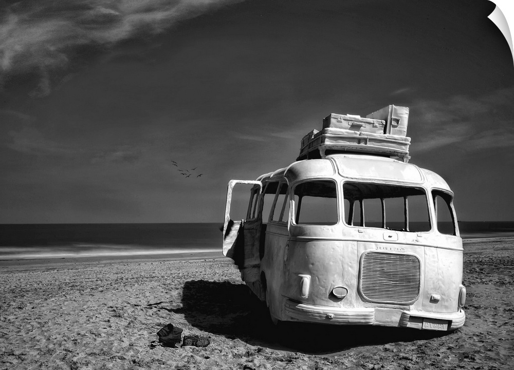 Black and white image of an abandoned bus with windows missing on a sandy beach in Belgium.