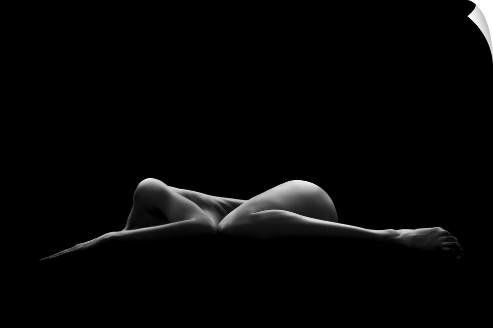 A nude female form seen partially illuminated in a dark environment.