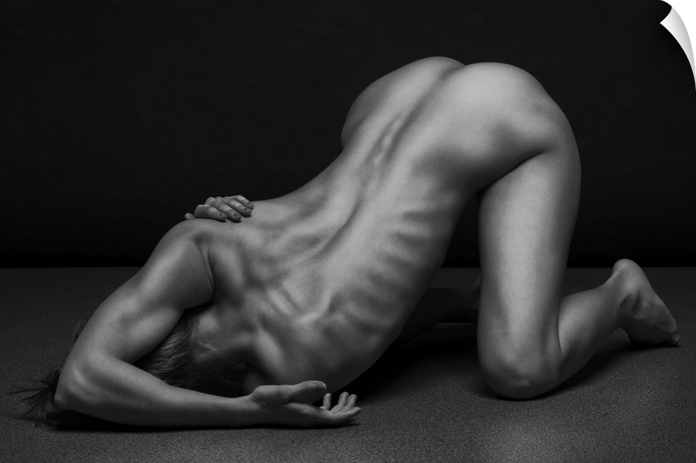 Black and white fine art photograph of a nude woman creating angles and shapes with her body.